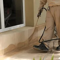 General pest control technician spraying exterior perimeter around a home in Gilbert, AZ