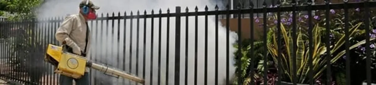 Mosquito control technician fogging a yard perimeter for mosquito reduction in Gilbert, AZ